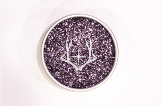 Round container with purple glitter on a white background